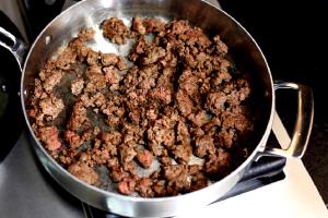 Quantas calorias em 1 Xícara, Crua, Produto Cozido Carne de Vaca Moída Extra Magra?